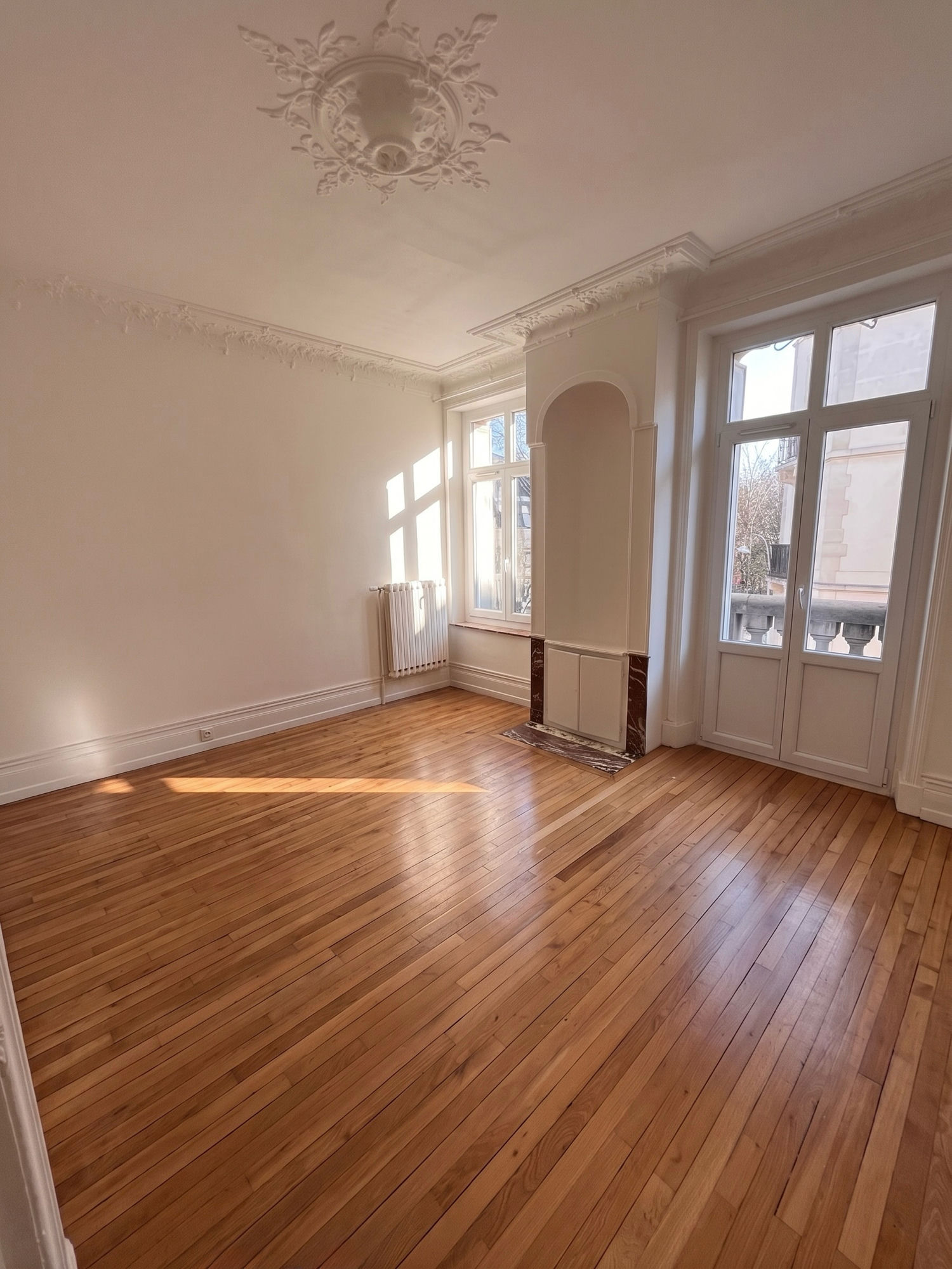 Salon : parquet, rosace et fenêtres sur rue